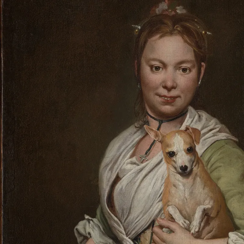 A portrait of a woman holding a small dog